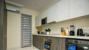 A modern kitchen with a built-in oven, microwave, and dishwasher.