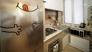 A kitchen with a stainless steel refrigerator, a stove, an oven, and a microwave. - Dimora delle Camelie (Aquarium) genovabnb it (GENOVA)