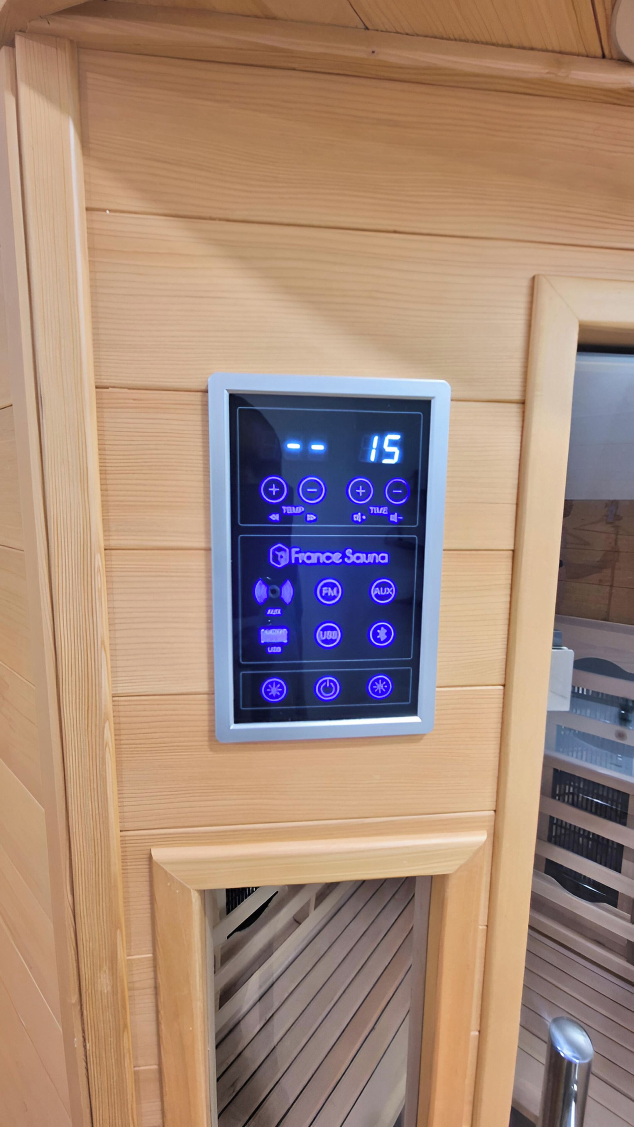Ein Sauna-Bedienfeld mit digitaler Anzeige, UKW-Radio und AUX-Anschluss.