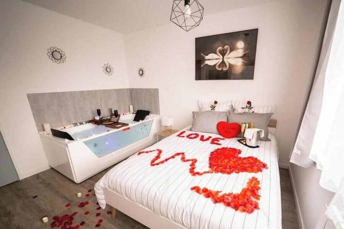 Een moderne slaapkamer met een groot bed, een los bad en een kunstwerk aan de muur.
