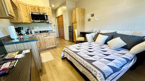A compact bedroom with a bed, a desk, and a kitchenette. - Year Round Monthly Rental Studio WIFi Desk Wild Mustangs nearby Nat'l For (Overgaard)