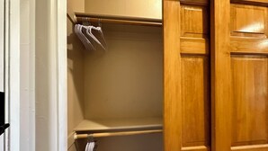 A wooden closet with a hanging rod and a shelf. - Year Round Monthly Rental Studio WIFi Desk Wild Mustangs nearby Nat'l For (Overgaard)