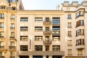 A multi-story building with balconies and large windows.