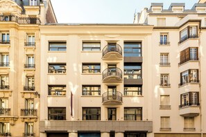 A multi-story building with a central staircase, large windows, and balconies.