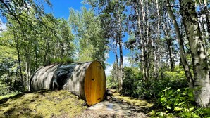 Maastossa, metsäisellä alueella, kivituhkapolulla makaa vanhanaikainen, maalaishenkinen puutynnyri.