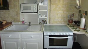 A compact kitchen with a sink, microwave, stove, and oven.