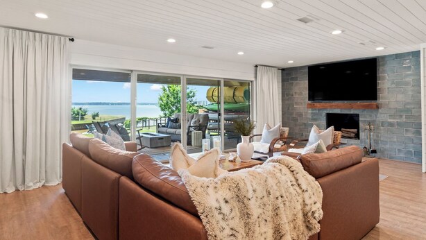 A living room with a large sofa, a fireplace, and a TV.