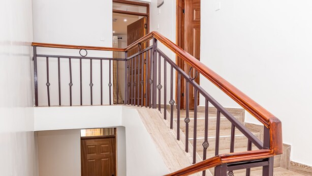 A multi-level staircase with wooden handrails and metal railings. - Calm Haven-Cozy Home in a Gated Community (Ruiru)