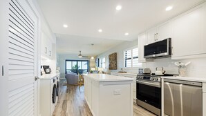 Een moderne keuken met witte kasten, roestvrijstalen apparatuur en een centraal eiland.