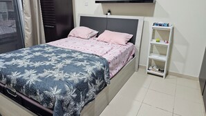 A bedroom with a bed, a nightstand, a shelf, and a window with curtains.