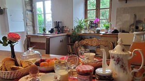 Une table mise pour le petit-déjeuner, avec une variété d'aliments, une machine à café et une vue sur l'extérieur.