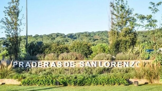 A sign with the text "PRADERAS DE SAN LORENZO" in a natural setting with greenery and hills in the background. - House in Meadows of San Lorenzo - San Lorenzo Chico / Salta (Salta)