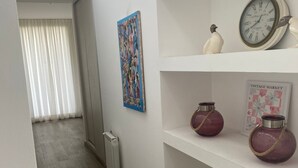 A hallway with a radiator, a clock, and decorative vases on shelves. - House in Meadows of San Lorenzo - San Lorenzo Chico / Salta (Salta)