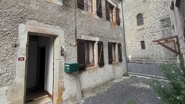 Un edificio de piedra con varias ventanas y un pequeño patio.