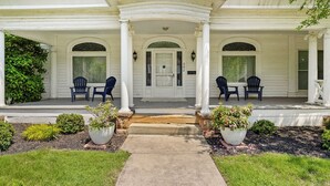 Une maison à deux étages avec un porche, deux fenêtres et une porte.