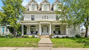 Une maison à deux étages avec un porche à l’avant, un hall d’entrée couvert et le numéro « 302 » sur la porte.