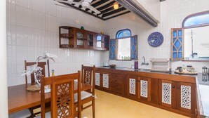 Een keuken met witte betegelde wanden, houten kasten en een centraal eiland.