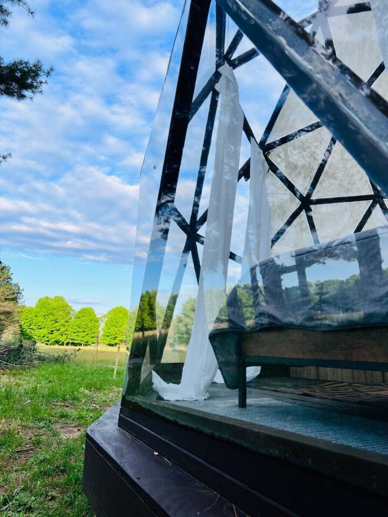 Eine klare Glasstruktur mit geometrischem Design, möglicherweise Teil eines Gebäudes oder einer Installation.