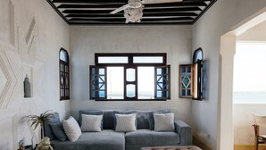A living room with a sectional sofa, ottoman, and a decorative monkey statue.