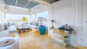 A spacious living area with a sofa set, a coffee table, and a large vase.