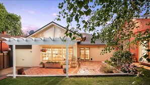A house with a covered patio, a brick pathway, and a well-maintained lawn. - Botanical Gardens Retreat | CBD walking distance (Albury)