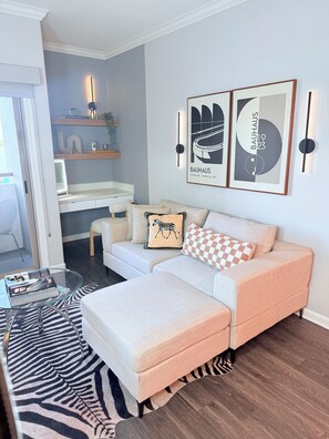 A modern living room with a sofa, a glass coffee table, and a zebra-patterned rug. - Prime Wilshire Blvd Residence - Pool,Gym (Beverly Hills)