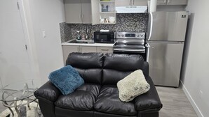 Una cucina moderna con mobili grigi, un frigorifero in acciaio inossidabile, un forno a microonde e un forno.
