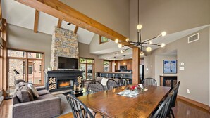 A spacious living area with a fireplace, dining table, and comfortable seating. - Tremblant Prestige - Altitude 170-9 (Mont-Tremblant)