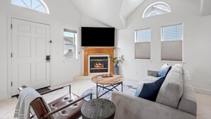 Amplia sala de estar con chimenea, un televisor de pantalla plana grande y una zona de estar confortable.
