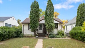 A two-story house with a front porch, a mailbox, and a well-maintained lawn. - Beautiful Basement Private Suite Prime Location (Winnipeg)