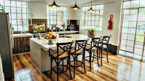 Una cocina moderna con una isla central, suelo de madera e iluminación colgante.