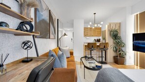 A modern living room with a sofa, coffee table, and a TV mounted on the wall.