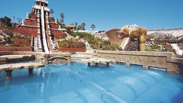 A pool with a water slide and a dinosaur statue. - Apartment Castle Harbour (Arona)