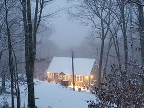 Een huis met een sneeuwbedekte kap en een zichtbare trap naar de ingang.