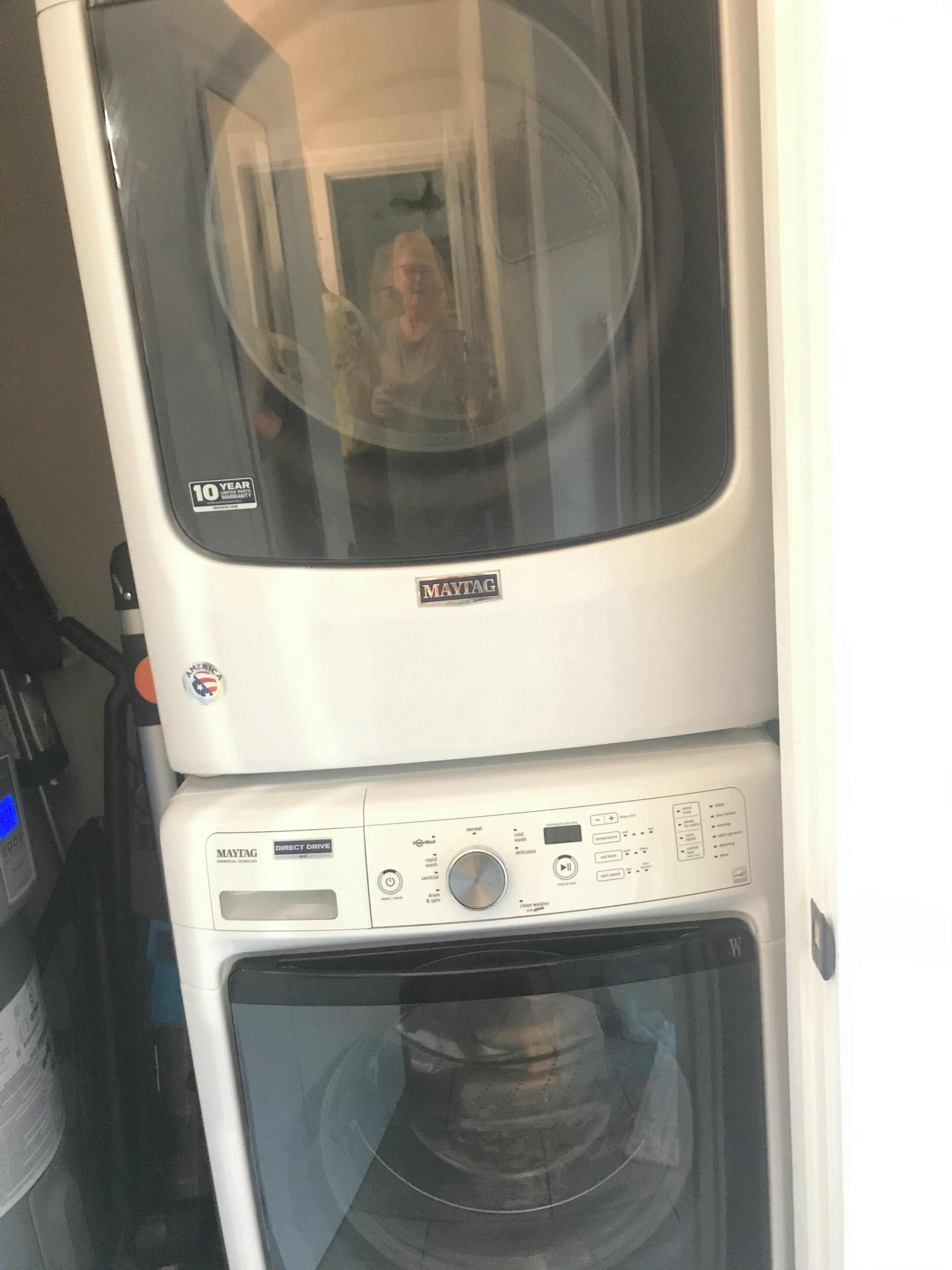 Eine Frontansicht einer Maytag Waschmaschine und Trockner Kombination mit 10-Jahres-Garantie-Aufkleber, Bedienfeld und einer großen Glasscheibe.
