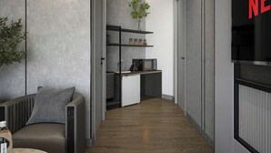 Un interior moderno con una zona de estar, kitchenette y una amplia pantalla de televisión.