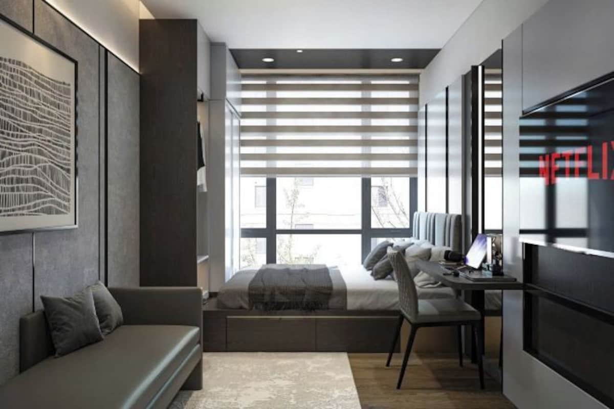 Un dormitorio moderno con cama, escritorio y zona de estar.