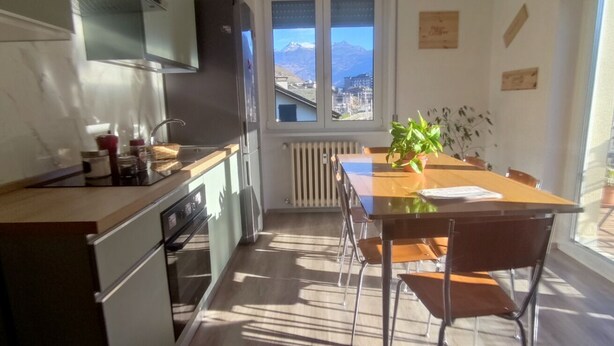 A kitchen with a window, a dining table, chairs, and a potted plant. - Tiranoexpress 2 floor (Tirano)