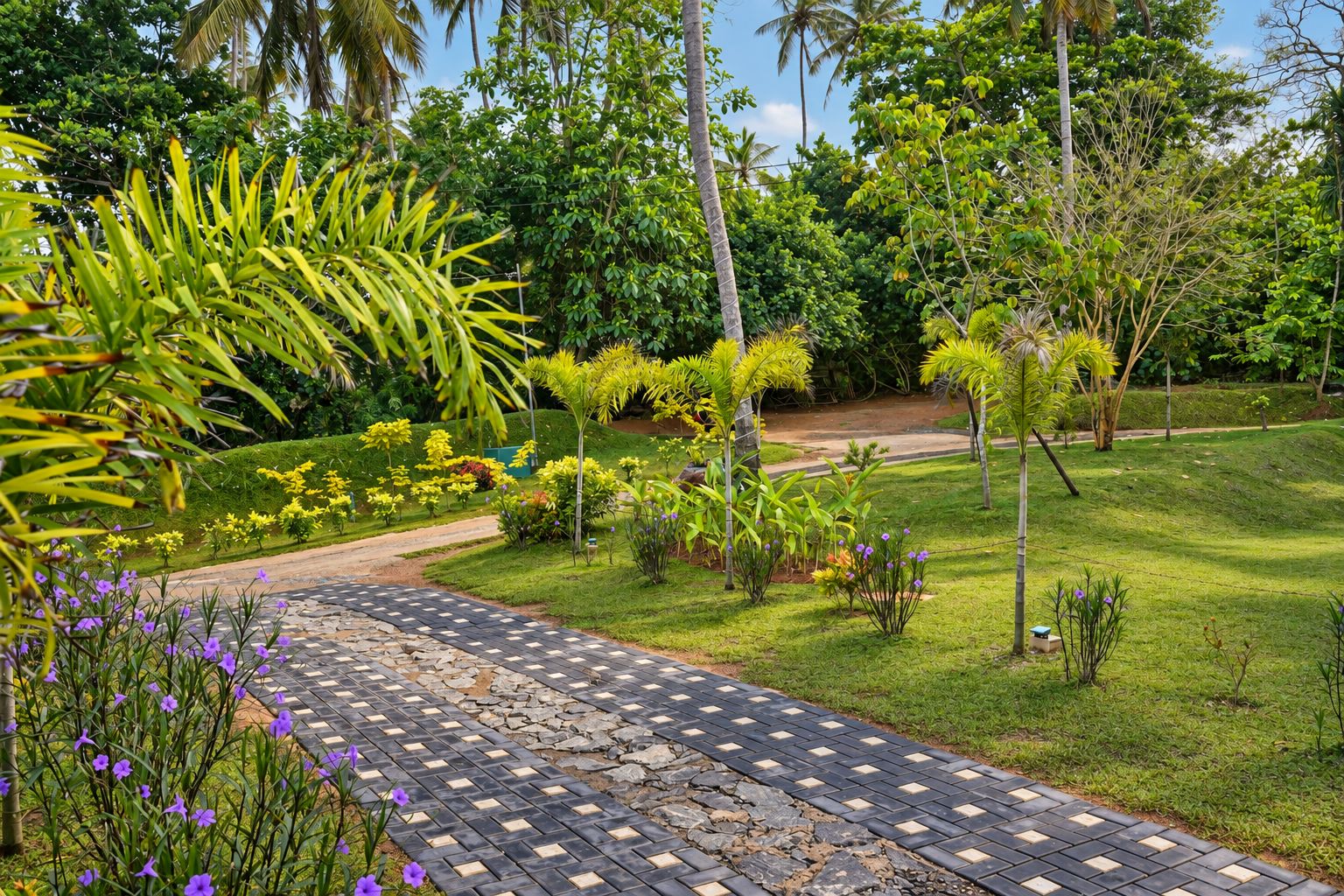 Un chemin pavé traverse un jardin luxuriant où poussent différentes espèces de plantes et d’arbres.