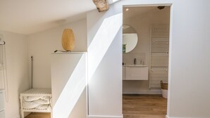A modern, minimalist bathroom with a shower, sink, and mirror. - Les Tamaris (SAINTE TERRE)