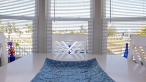 A room with a white table, a blue patterned rug, and white chairs. - Pond View 2BR 2BA Beach Escape (Fort Myers Beach)