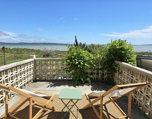 On the edge of a salt pond, house with terrace facing the water and pink flamingos