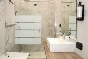 Eenpersoonskamer | Badkamer | Een douche, een haardroger, pantoffels, handdoeken