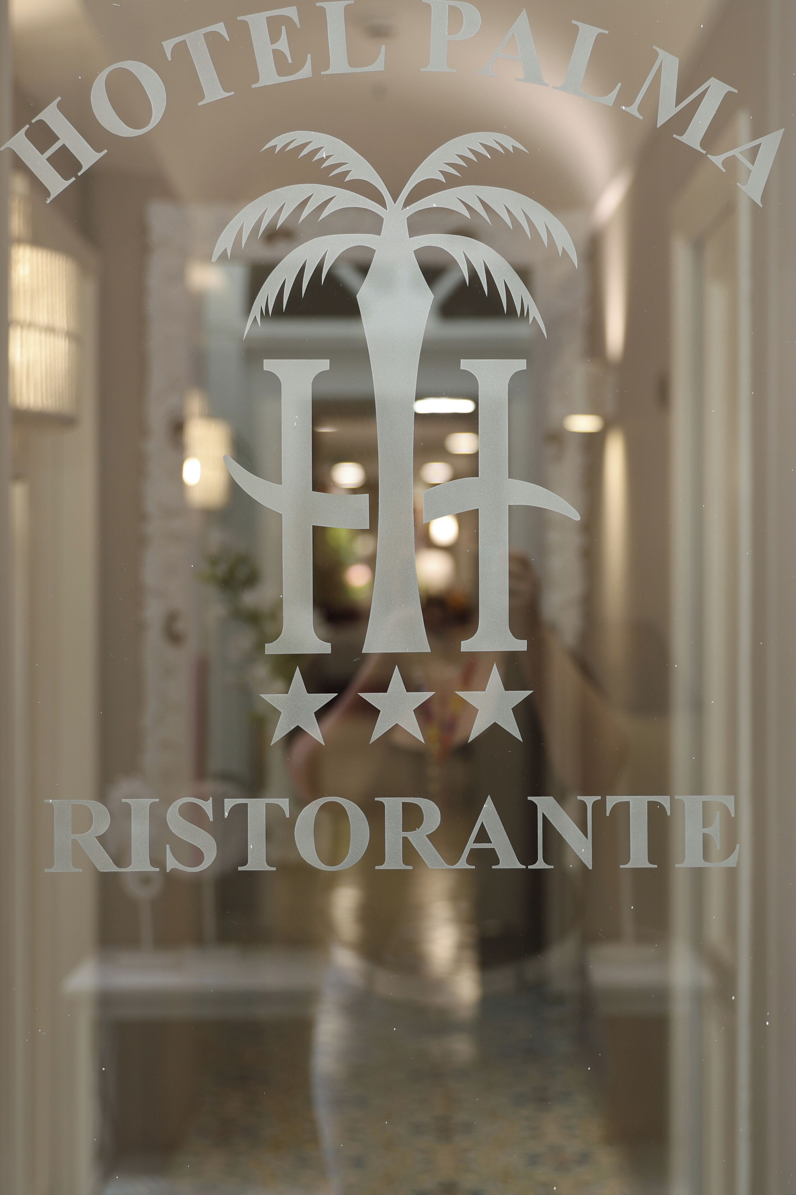 A hotel sign with a palm tree and stars, indicating a hotel and restaurant.