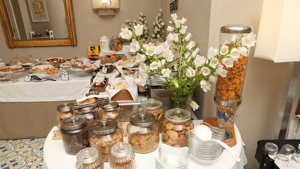 Een buffettafel met diverse soorten eten, zoals gebak, koekjes en ontbijtgranen.