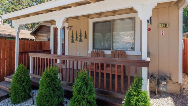 Una baita di legno con un portico, una veranda coperta e il numero 538.
