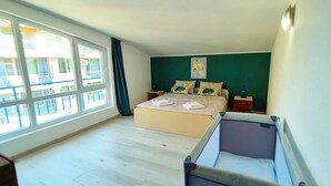 Une chambre à coucher avec un grand lit, une table de chevet, une commode, une fenêtre et une vue sur l’extérieur.