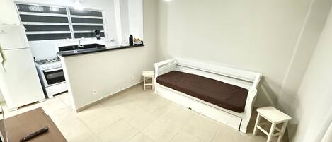 A compact living space with a kitchenette, a bed, and a small table.