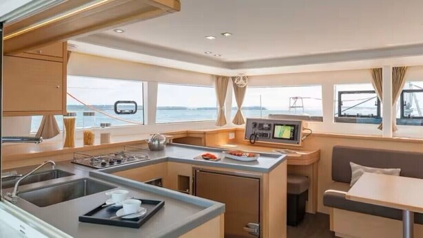 A compact kitchen with a central island, a dining area, and a view of the sea. - Stay Together, "Somewhere" - 4 Bed & 4 Bath - Catamaran in Key West (Key West)