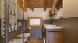 A compact bathroom with a toilet, sink, and window. - Zarabella Delle Alpi (Temù)